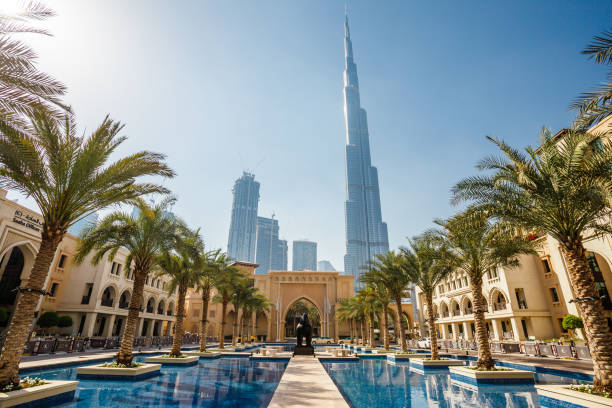 A picturesque view of Burj Khalifa surrounded by modern architecture and palm trees, exemplifying Dubai's allure.