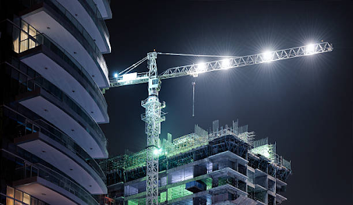 Night construction at Binghatti Hills with a crane and partially built structure illuminates progress.